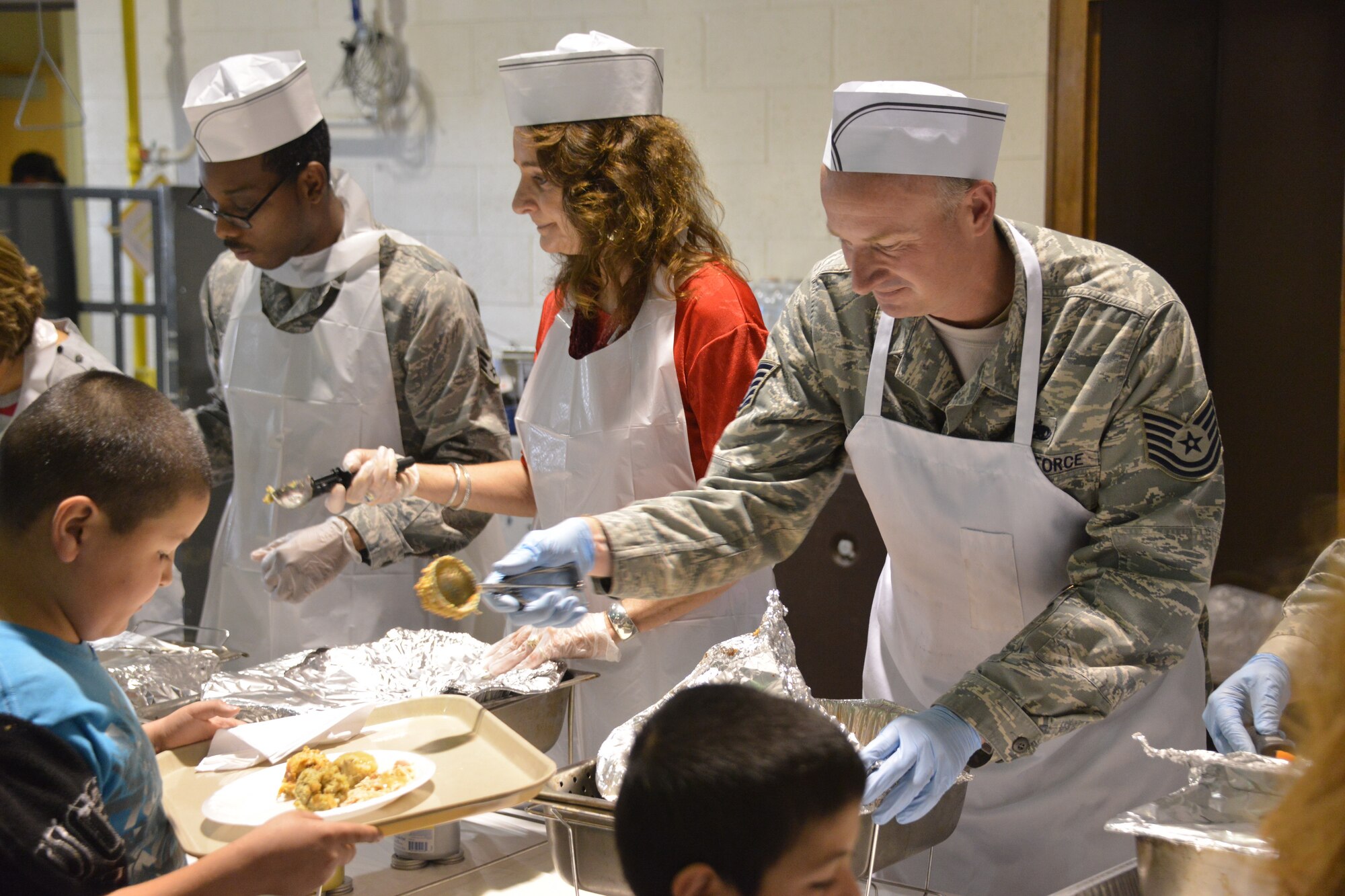 Food is served at Operation Holiday Cheer Dec. 18, one of Kirtland's biggest charitable events of the year. Hundreds of volunteers helped prepare and serve food at the event, which fed more than 1,000 from the local community. In addition, hundreds of new toys were delivered to children. (Photo by Todd Berenger)
