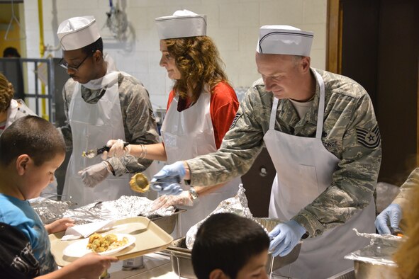 Food is served at Operation Holiday Cheer Dec. 18, one of Kirtland's biggest charitable events of the year. Hundreds of volunteers helped prepare and serve food at the event, which fed more than 1,000 from the local community. In addition, hundreds of new toys were delivered to children. (Photo by Todd Berenger)
