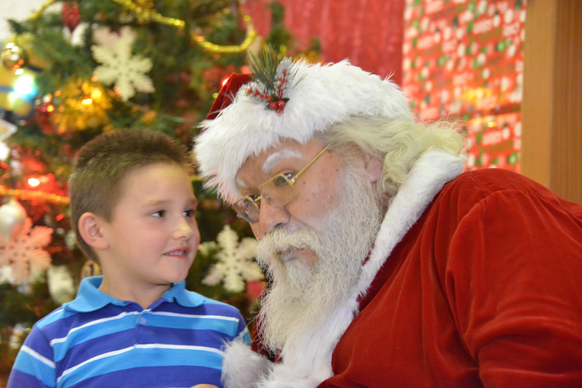 Santa Claus visits with 6-year-old Jonathon Montellano at Operation Holiday Cheer Dec. 18, one of Kirtland's biggest charitable events of the year. More than 1,000 people from the local community were fed, and hundreds of new toys were delivered to children. The annual event was hosted by the Kirtland Fire Department. (Photo by Todd Berenger)
