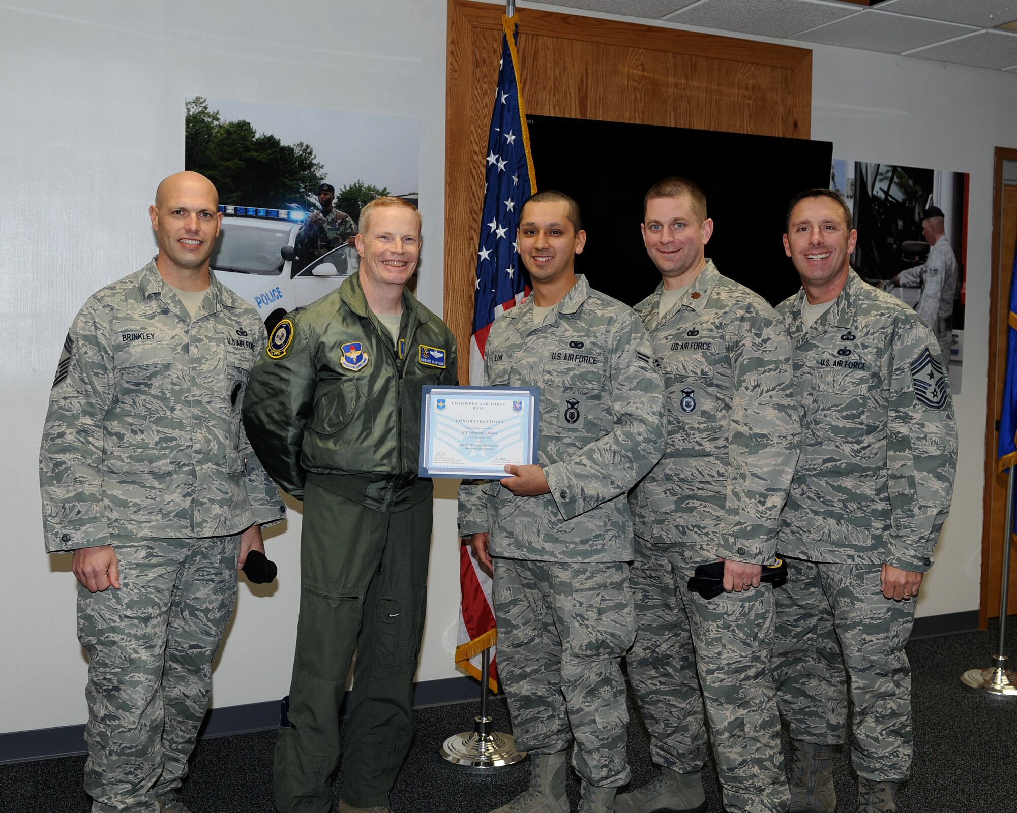 Chief Master Sgt. David Brinkley, 14th Security Forces Squadron Security Forces Manager, Col. Howard McArthur, 14th Flying Training Wing Vice Commander, Maj. Brenton Pickrell, 14th Security Forces Squadron Commander, and Chief Master Sgt. Vance Kondon, 14th Flying Training Wing Command Chief, pose for a photo with Airman 1st Class Valentino Blank, 14th Security Forces Squadron, who was awarded Senior Airman Below the Zone Dec. 11 at the 14th Security Forces Squadron.