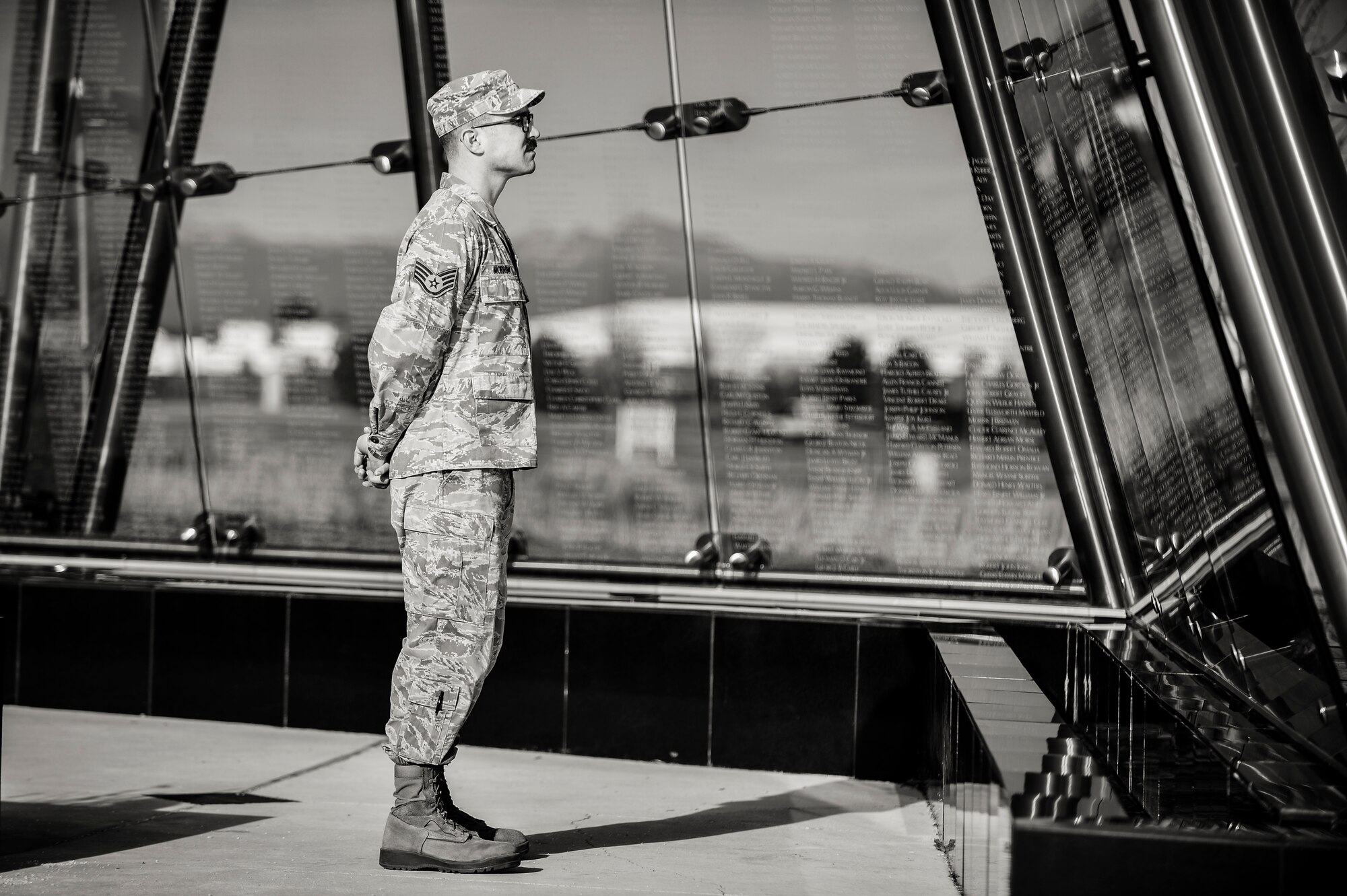 Staff Sgt. Lucas Morrow, 460th Space Wing Public Affairs, reads the names of fallen Colorado veterans at the Colorado Freedom Memorial Dec. 12, 2013, in Springhill Community Park in Aurora, Colo. The Colorado Freedom Memorial is the first monument in the country to honor all service members from one state who were killed or missing in action from the Spanish-American war to the present. (U.S. Air Force photo by Senior Airman Riley Johnson/Released)