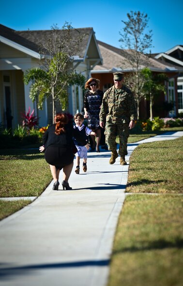 Evan Vaughan runs for a hug prior to MacDill Air Force Base’s Americans with Disabilities Act home unveiling, Dec. 18, 2013. Evan and the Vaughan family were one of the 10 families to be selected to live in the recently constructed ADA homes.  (U.S. Air Force photo by Staff Sgt. Brandon Shapiro/Released) 