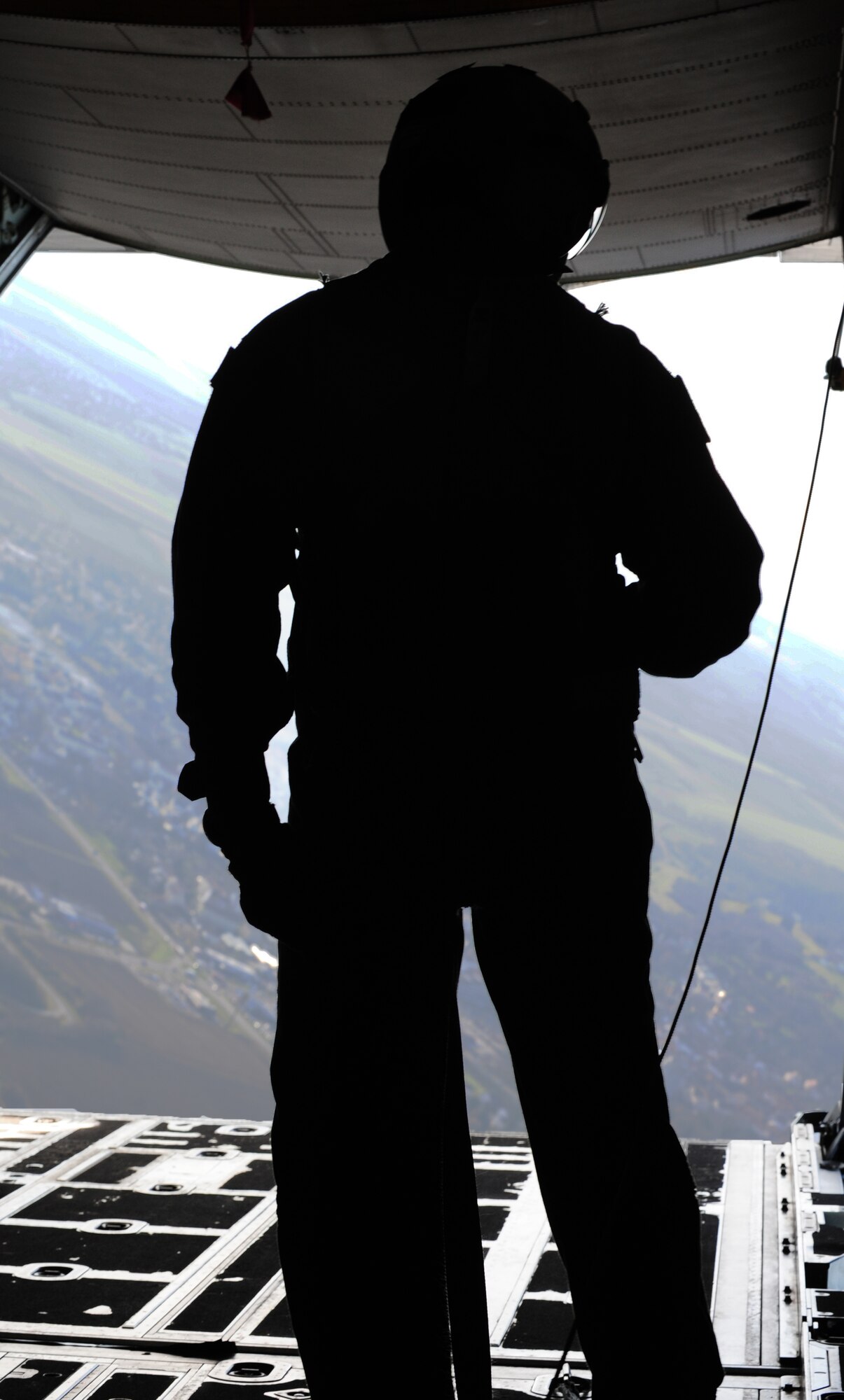A loadmaster watches as the paratroopers take a dive out of a C-130J Super Hercules during International Jump Week, Dec. 17, 2013, Ramstein Air Base, Germany. International Jump Week started with a bang this year as Santa Claus joined service members from different branches of the U.S. along with NATO forces. (U.S. Air Force photo/Senior Airman Hailey Haux)