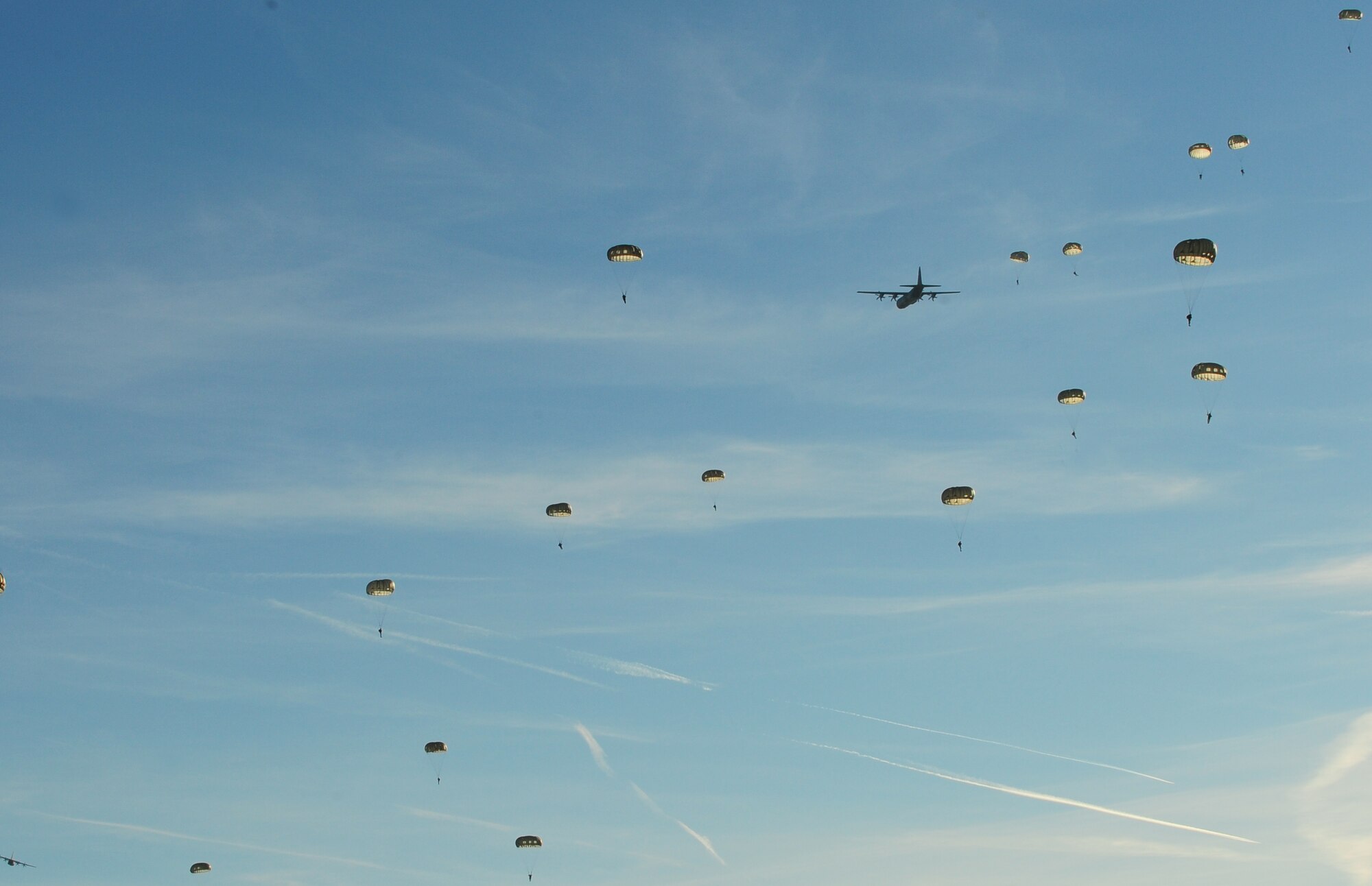 Paratroopers fall from the sky as they participate in International Jump Week, Dec. 16, 2013, Ramstein Air Base, Germany. Jump Week is a chance for NATO countries and U.S. forces can build partnerships and train together. (U.S. Air Force photo/Senior Airman Hailey Haux)