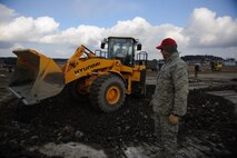 Master Sgt. William Webb, Detachment 1, 554 RED HORSE, watches an 8th Civil Engineer Squadron Airman flatten rocks during a training Silver Flag exercise at Kunsan Air Base, Republic of Korea, Dec. 19, 2013. Members from Detachment 1 554 RED HORSE came to Kunsan to train and develop civil engineer Airmen during the week long Silver Flag exercise. (U.S. Air Force photo by Senior Airman Armando A. Schwier-Morales/Released)
