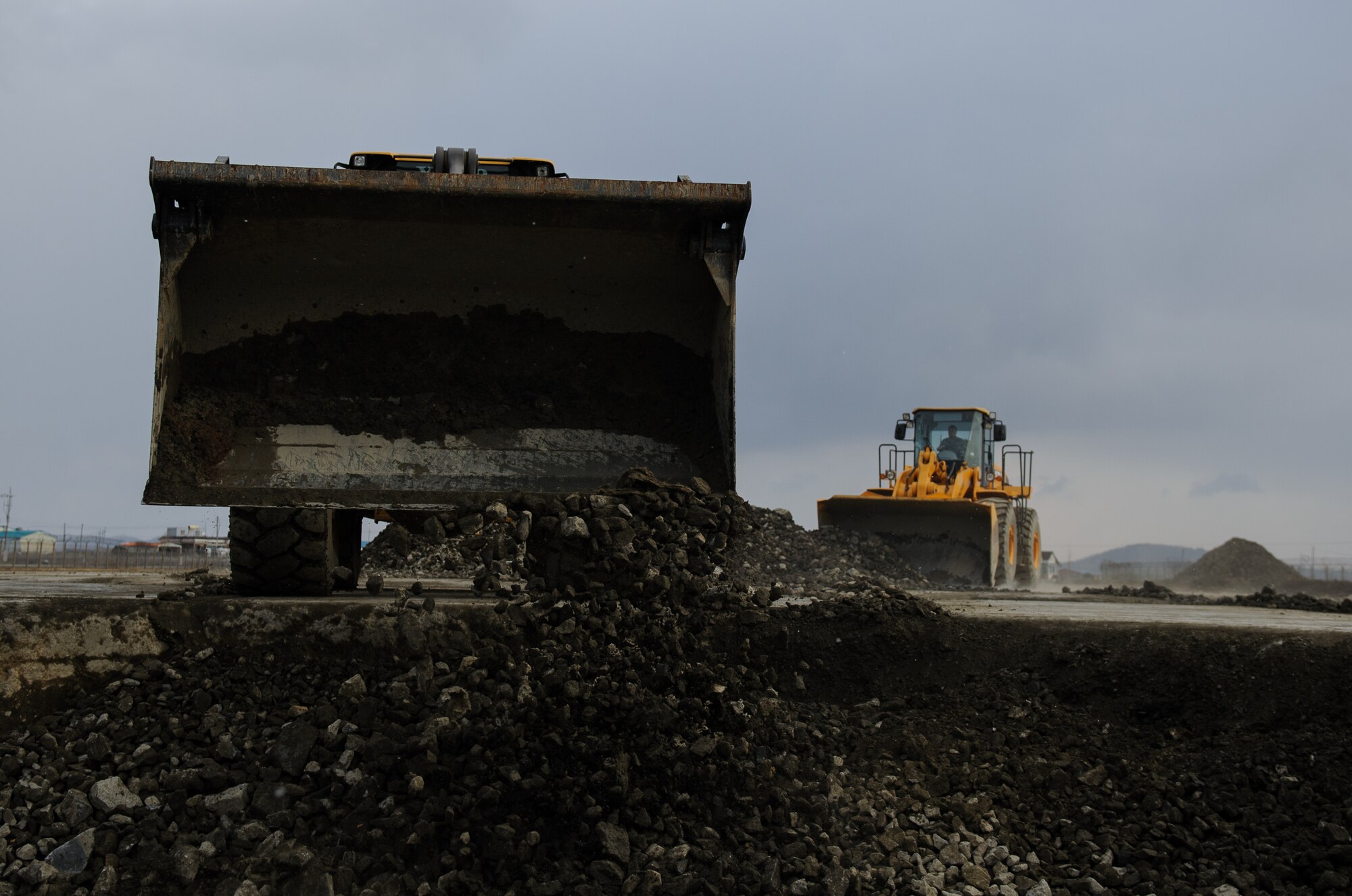 Staff Sgt. Souridet Thongrivong and Senior Airman Todd Michael, 8th Civil Engineer Squadron, fill a crater with rocks during an Airfield Damage Repair exercise at Kunsan Air Base, Republic of Korea, Dec. 19, 2013. Members from Detachment 1 554 RED HORSE came to Kunsan to train and develop civil engineer Airmen during the week long Silver Flag exercise. (U.S. Air Force photo by Senior Airman Armando A. Schwier-Morales/Released)