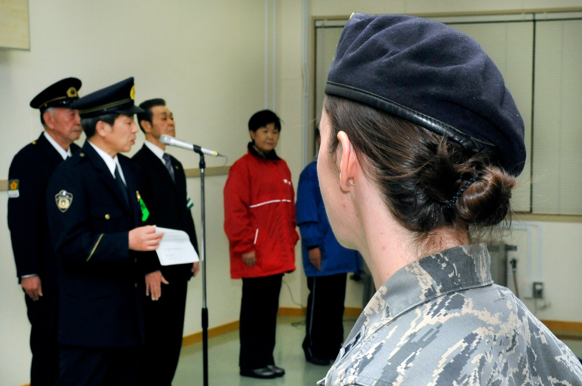U.S. Air Force Capt. Julie Roloson, 35th Security Forces Squadron operations officer, looks on as Toshiyuki Adachi, chief of Misawa police station, speaks during the annual Safety and Crime Prevention Campaign meeting in Misawa City, Japan, Dec. 17, 2013. Members from the Misawa and Aomori police stations, along with Misawa Air Base and 35 SFS leadership attended the meeting prior to going on a joint-bilateral town patrol. (U.S. Air Force photo by Airman 1st Class Zachary Kee)