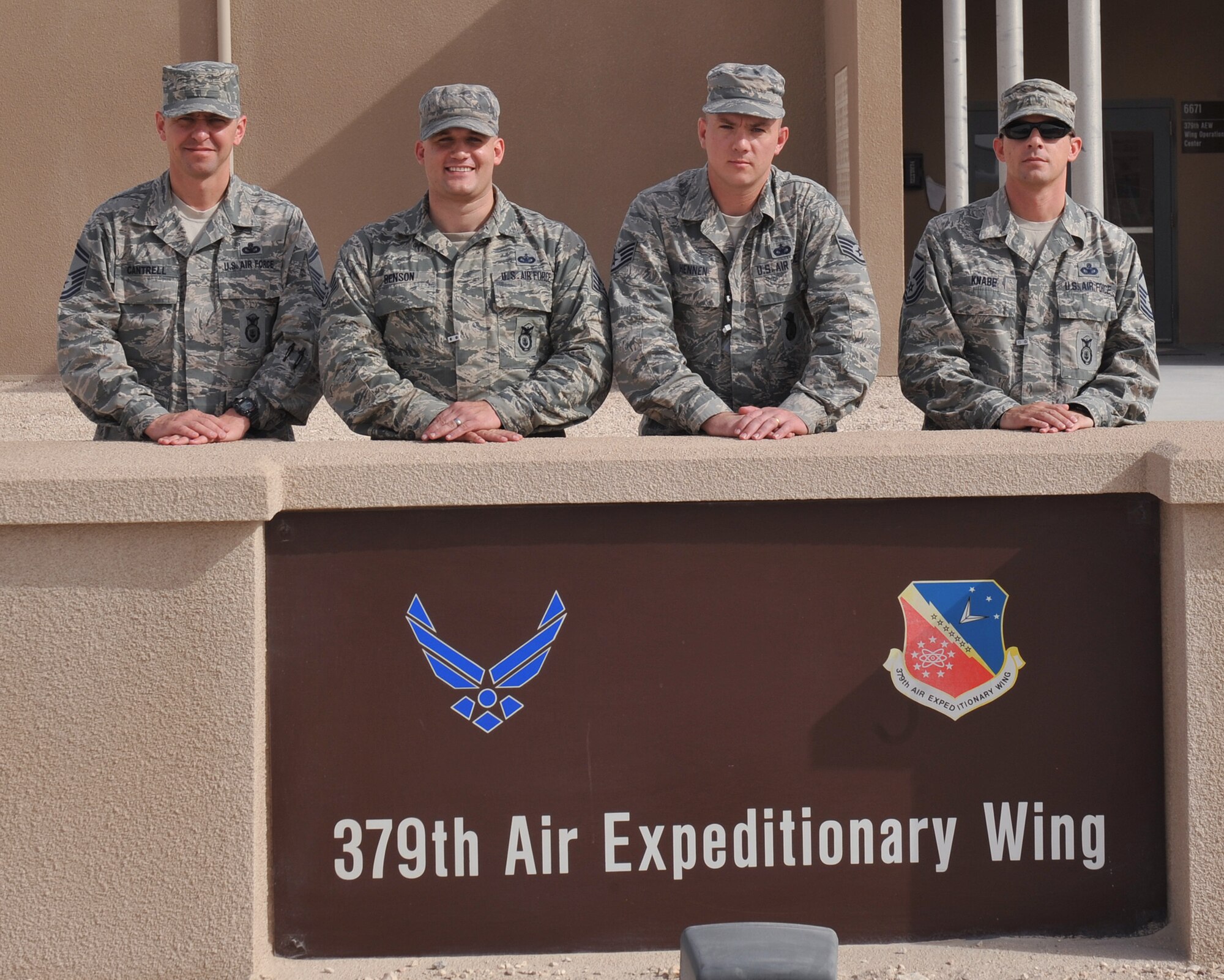The Check Six staff pose for a group photo outside the 379th Air Expeditionary Wing wing operation center Dec. 13, 2013, at the 379th AEW, Southwest Asia. The Check Six program is designed to promote vigilance and combat complacency. This helps Airmen refocus so they can react during an active shooter event. (U.S. Air Force photo by Master Sgt. David Miller)