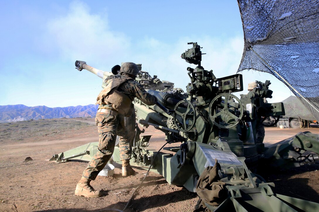 Marine Corps Pfc. Arnold Millan rushes to an M777 lightweight howitzer to clear the barrel and reload after firing a mission during Exercise Steel Knight 2014 on Marine Corps Base Camp Pendleton, Calif., Dec. 13, 2013. Millan, a artilleryman, is assigned to Bravo Battery, 1st Battalion, 11th Marine Regiment.