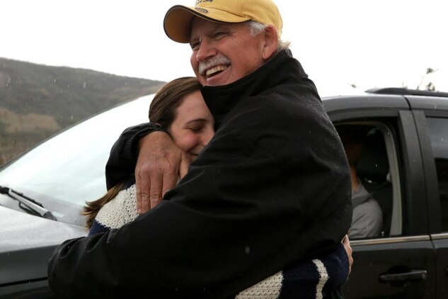 Victoria Courtnage hugs Dan Graham after her family received a holiday ham and gift cards during the Armed Services YMCA's Secret Santa Event Dec. 19. Grahm is one of 131 sponsors who donated gifts to military families. 