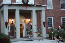 Marines and sailors with 2nd Medical Battalion, Combat Logistics Regiment 25, 2nd Marine Logistics Group enter the 2nd MLG headquarters building during a reindeer run aboard Camp Lejeune, N.C., Dec. 20, 2013. Service members shouted season’s greetings to the personnel of the building while dashing through corridors. (U.S. Marine Corps photo by Lance Cpl. Shawn Valosin)