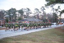 Marines and sailors with 2nd Medical Battalion, Combat Logistics Regiment 25, 2nd Marine Logistics Group run towards Soiffert field after leaving the 2nd MLG headquarters building during a reindeer run aboard Camp Lejeune, N.C., Dec. 20, 2013. Service members wore bells on their left shoe and wore santa hats. (U.S. Marine Corps photo by Lance Cpl. Shawn Valosin)