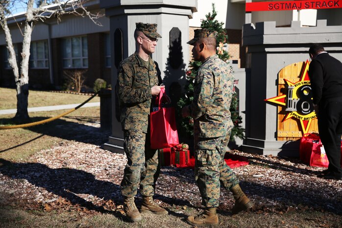 Marines with 8th Engineer Support Battalion, 2nd Marine Logistics Group embrace the generous spirit of Christmas, lending a hand to their fellow service members.  Lt. Col. Ferdinand F. Llantero, the commanding officer of 8th ESB, presented an assortment of Christmas gifts to selected service members in front of the 8th ESB castle, here, Dec. 19. Service members with children were selected by their peers and chain of command to receive the gifts, which they can give to their children on Christmas.