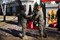 Marines with 8th Engineer Support Battalion, 2nd Marine Logistics Group embrace the generous spirit of Christmas, lending a hand to their fellow service members.  Lt. Col. Ferdinand F. Llantero, the commanding officer of 8th ESB, presented an assortment of Christmas gifts to selected service members in front of the 8th ESB castle, here, Dec. 19. Service members with children were selected by their peers and chain of command to receive the gifts, which they can give to their children on Christmas.