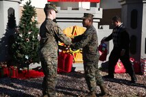 Marines with 8th Engineer Support Battalion, 2nd Marine Logistics Group embrace the generous spirit of Christmas, lending a hand to their fellow service members.  Lt. Col. Ferdinand F. Llantero, the commanding officer of 8th ESB, presented an assortment of Christmas gifts to selected service members in front of the 8th ESB castle, here, Dec. 19. Service members with children were selected by their peers and chain of command to receive the gifts, which they can give to their children on Christmas.