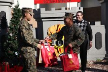 Marines with 8th Engineer Support Battalion, 2nd Marine Logistics Group embrace the generous spirit of Christmas, lending a hand to their fellow service members.  Lt. Col. Ferdinand F. Llantero, the commanding officer of 8th ESB, presented an assortment of Christmas gifts to selected service members in front of the 8th ESB castle, here, Dec. 19. Service members with children were selected by their peers and chain of command to receive the gifts, which they can give to their children on Christmas.