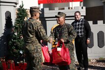 Marines with 8th Engineer Support Battalion, 2nd Marine Logistics Group embrace the generous spirit of Christmas, lending a hand to their fellow service members.  Lt. Col. Ferdinand F. Llantero, the commanding officer of 8th ESB, presented an assortment of Christmas gifts to selected service members in front of the 8th ESB castle, here, Dec. 19. Service members with children were selected by their peers and chain of command to receive the gifts, which they can give to their children on Christmas.