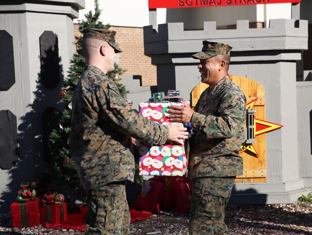 Marines with 8th Engineer Support Battalion, 2nd Marine Logistics Group embrace the generous spirit of Christmas, lending a hand to their fellow service members.  Lt. Col. Ferdinand F. Llantero, the commanding officer of 8th ESB, presented an assortment of Christmas gifts to selected service members in front of the 8th ESB castle, here, Dec. 19. Service members with children were selected by their peers and chain of command to receive the gifts, which they can give to their children on Christmas.