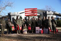 Marines with 8th Engineer Support Battalion, 2nd Marine Logistics Group embrace the generous spirit of Christmas, lending a hand to their fellow service members.  Lt. Col. Ferdinand F. Llantero, the commanding officer of 8th ESB, presented an assortment of Christmas gifts to selected service members in front of the 8th ESB castle, here, Dec. 19. Service members with children were selected by their peers and chain of command to receive the gifts, which they can give to their children on Christmas.
