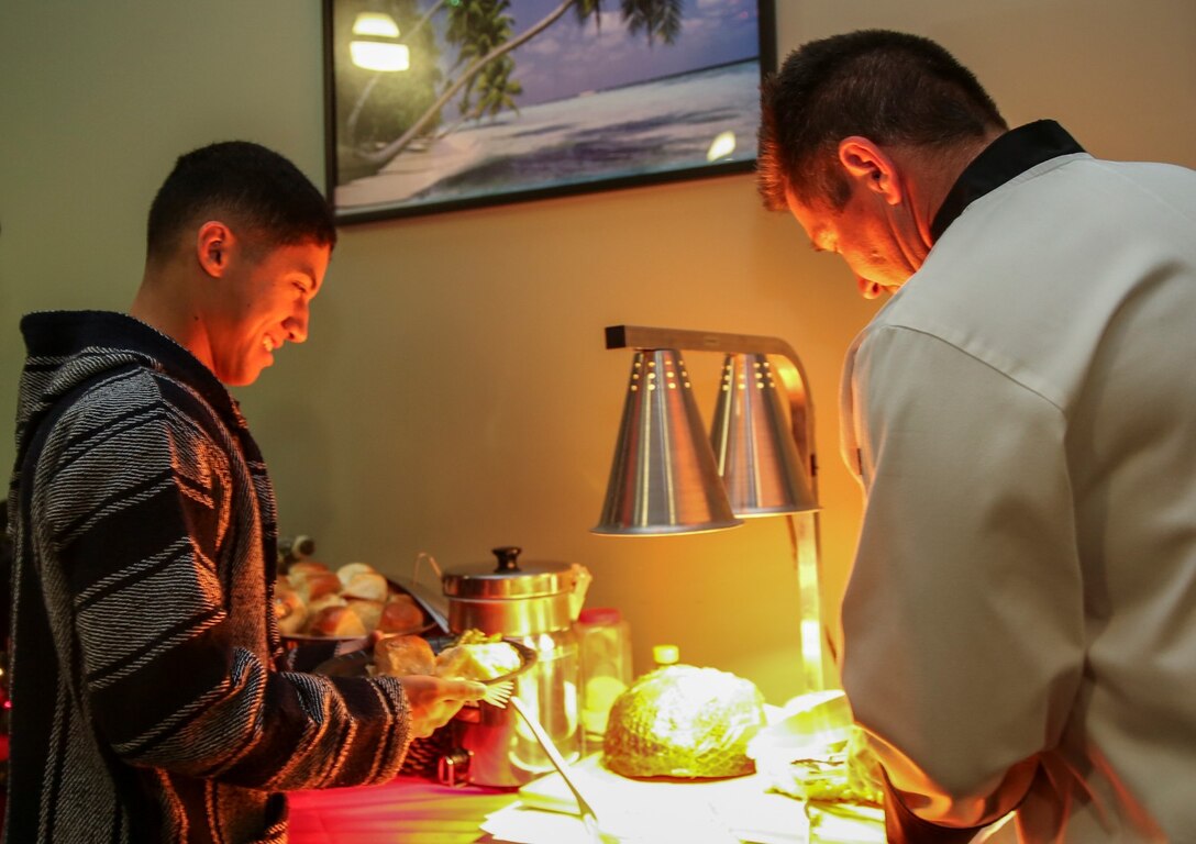Corporal Richard Hernandez, data network specialist, 15th Marine Expeditionary Unit, waits to be served a slice of turkey during a holiday meal at the 21 Area Single Marine Program recreation center aboard Camp Pendleton, Calif., on Dec. 18. Single Marines were invited to enjoy a home cooked meal and celebrate the holidays among friends during an event hosted by the 21 area family readiness officers.  Hernandez, 22, is from Temecula, Calif. (U.S. Marine Corps photo by Cpl. Emmanuel Ramos)