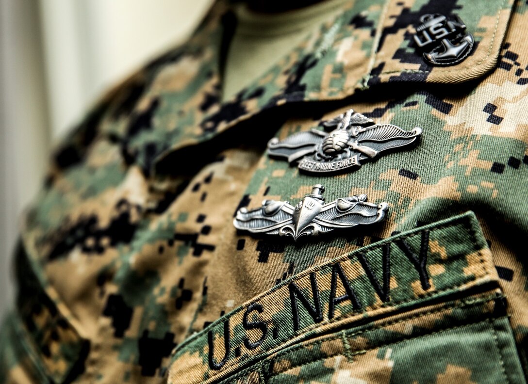 Chief Petty Officer Emmanuel Essenete, medical chief, 15th Marine Expeditionary Unit, proudly wears his Enlisted Fleet Marine Force and Surface Warfare specialist devices at his office aboard Camp Pendleton, Calif., Dec. 19. The devices are earned by completing personal qualification standards and qualification boards. Essenete, 35, is from Los Angeles. (U.S. Marine Corps photo by Cpl. Emmanuel Ramos)