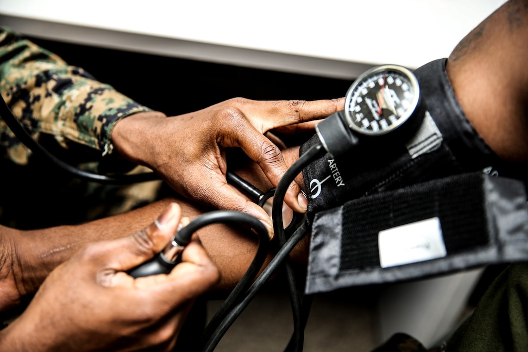 Petty Officer 3rd Class Rylan Burchell, hospital corpsman, 15th Marine Expeditionary Unit, conducts a check up on a patient aboard Camp Pendleton, Calif., Dec. 19. Burchell is studying the for Enlisted Fleet Marine Force Specialist exam and preparing for his qualification board. Burchell, 25, is from Kingston, Jamaica. (U.S. Marine Corps photo by Cpl. Emmanuel Ramos)
