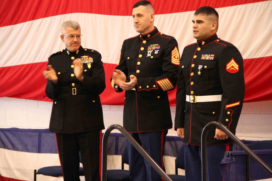 Brigadier General James S. Hartsell, commanding general of the 4th Marine Division, and First Sgt. Michael S. Ryan, applaud Cpl. Ethan Nagel for recieving the Silver Star, Dec. 17.