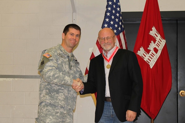 Randy Braley shakes hands with Col. Mark Deschenes, Rock Island District Commander, after being awarded the Order of the de Fleury Medal Dec. 9 for his service and support as the Kabul Area office, Afghanistan resident engineer and for his 32-years as a Corps of Engineers employee.