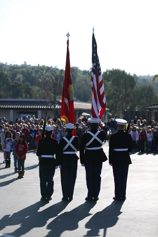 The color guard with Marine Aircraft Group (MAG) 39 retires the colors at the end of a ceremony at Carillo Elementary School, Dec. 20. Marines from MAG-39 were given donations from the school including food, toys, clothing and other lightly used goods for Marine families in need.