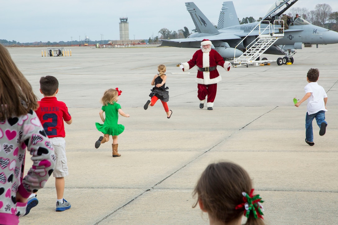 Children run towards Santa as he arrives at the Marine All-Weather Fighter Attack Squadron 533 Christmas party, Dec. 7. Santa showed up in one of the squadrons F-18s.  
