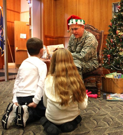 Col. Scotty Howlin, Hill’s Sustainment Center Engineering Deputy, reads Christmas stories to Carter Wilcox and sister Abbey. (Photo by Tim Broussard, Hilltop Times Correspondent)