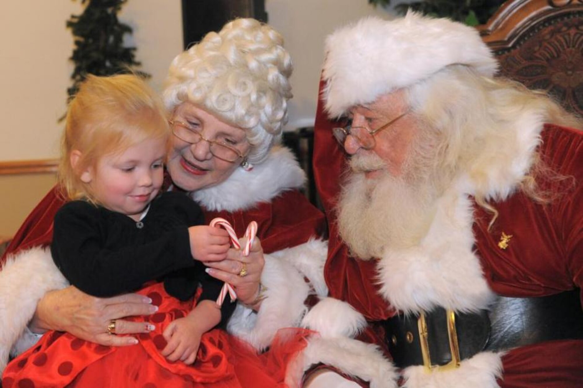 Abigail Coleman gets a candy cane from Mrs. Claus dressed in some of her holiday best as she gets her chance to tell Mr. Claus what she wants for Christmas at an event at the Landing on Dec. 11. At the event, supported in part by Operation Homefront, children got the chance to try their hand at different crafts, see Santa and pick out a present. (Todd Cromar/U.S. Air Force)