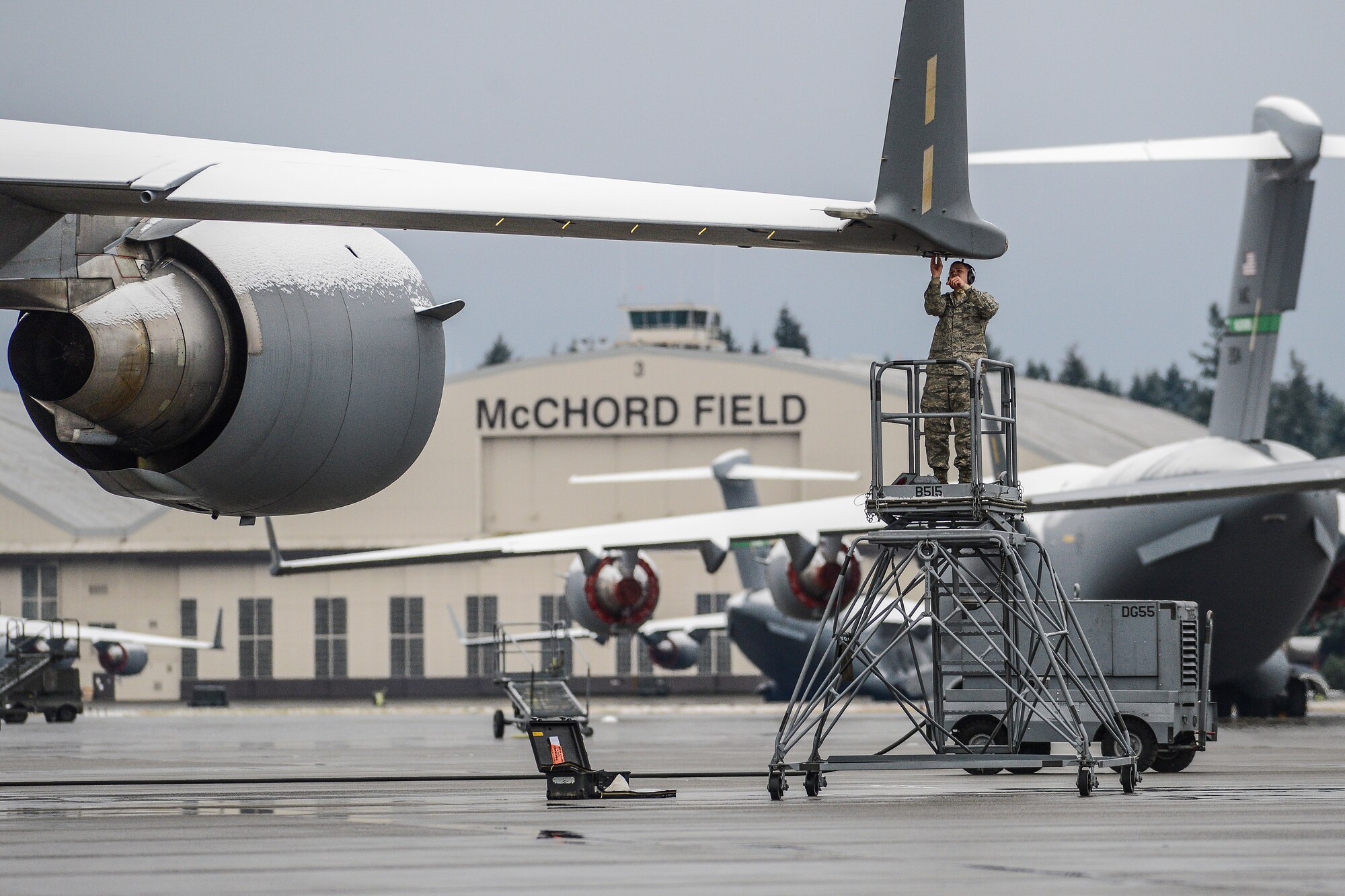 Airman 1st Class Jerry Bentley, 62nd Aircraft Maintenance Squadron electrical and environmental systems technician, braves the cold Dec. 20, 2013, to troubleshoot an electrical fault in a wiring harness located in the right wing of a C-17 Globemaster III at Joint Base Lewis-McChord, Wash. JBLM received a light dusting of snow in the early morning which turned to rain later in the day, creating cold, soggy working conditions for McChord Field maintainers. (U.S. Air Force photo/Tech. Sgt. Sean Tobin)