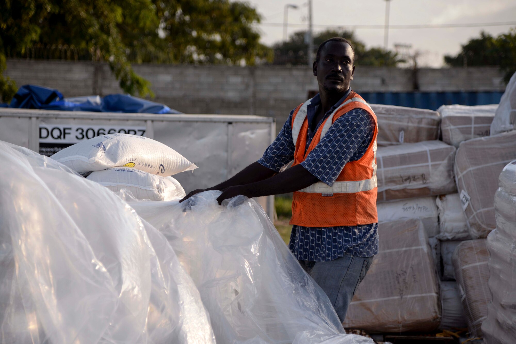 Port-au-Prince, Haiti – A Haitian citizen opens up a pallet of sacks of rice at Port-au-Prince, Haiti Dec. 19, 2013. Airmen assigned to the 97th Air Mobility Wing executed a humanitarian aid mission to deliver 136,000 pounds of rice, beans and corn meal that was provided by Operation Ukraine, a non-profit relief organization that collects and distributes supplies around the world. (U.S. Air Force photo by Airman 1st Class Klynne Pearl Serrano/Released)