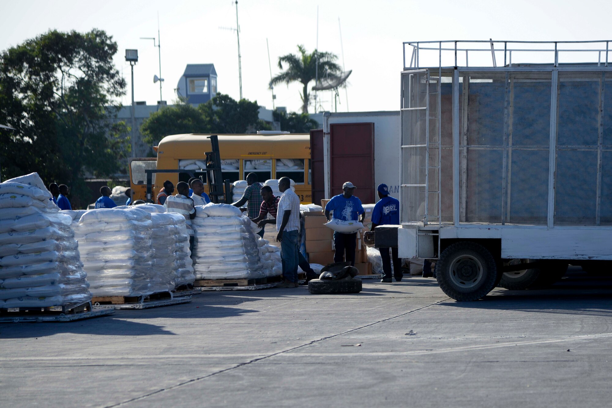 Port-au-Prince, Haiti – Haitian citizens load trucks with sacks of rice at Port-au-Prince, Haiti Dec. 19, 2013. Airmen assigned to the 97th Air Mobility Wing delivered 136,000 pounds of rice, beans and corn meal provided by Operation Ukraine, a non-profit relief organization that collects and distributes supplies around the world. (U.S. Air Force photo by Airman 1st Class Klynne Pearl Serrano/Released)