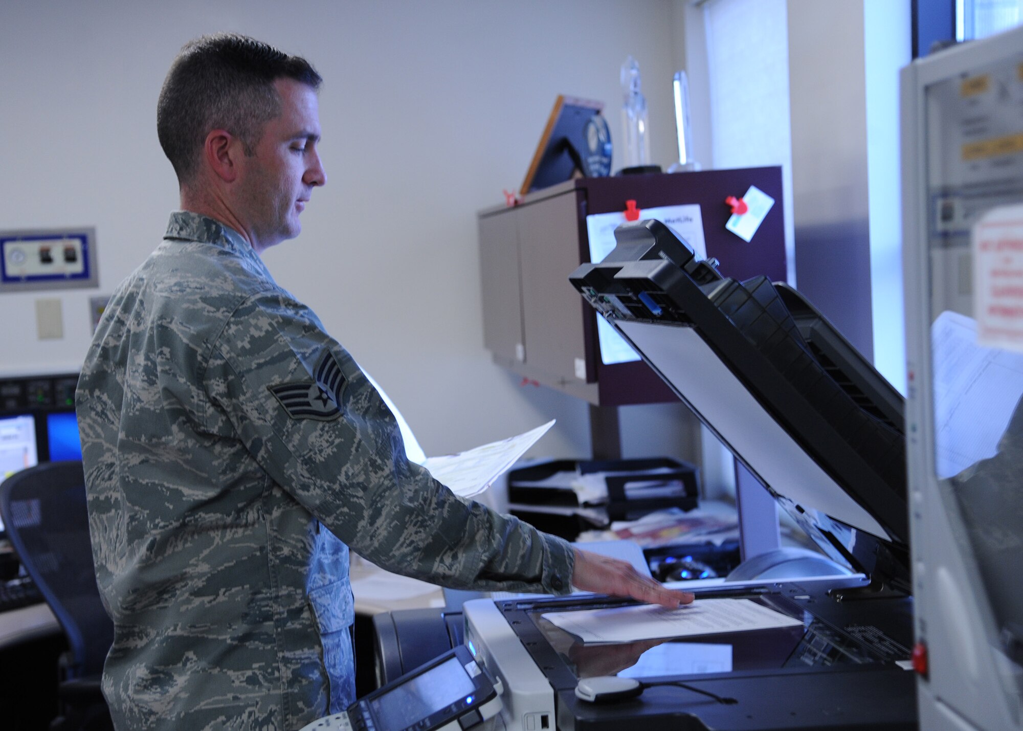 Staff Sgt. Jacob Webb, 341st Medical Operations Squadron dental Personnel Reliability Program administrator, makes copies of paperwork at the clinic Dec. 4. According to several dental Airmen, teamwork and morale help keep Malmstrom’s Dental Clinic running smoothly. (U.S. Air Force photo/Senior Airman Cortney Paxton)