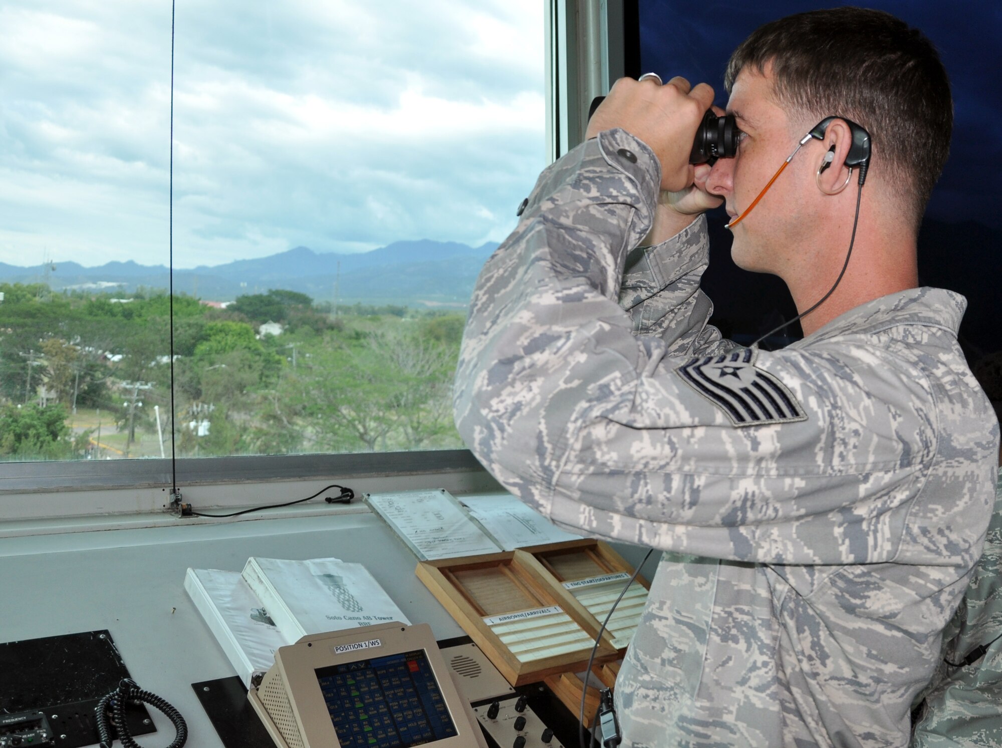 U.S. Air Force Tech. Sgt. Charles Simper, an Air Traffic Control Watch Supervisor assigned to the 612th Air Base Squadron, Joint Task Force Bravo, directs air traffic from the control tower at Soto Cano Air Base, Honduras, Dec. 19, 2013. Air traffic controllers in the tower are responsible for directing air traffic departing and arriving at Soto Cano, as well as vehicle traffic that occurs on the controlled movement area (CMA), which includes the area of the landing zones and runways. (U.S. Air Force photo by Capt. Zach Anderson)