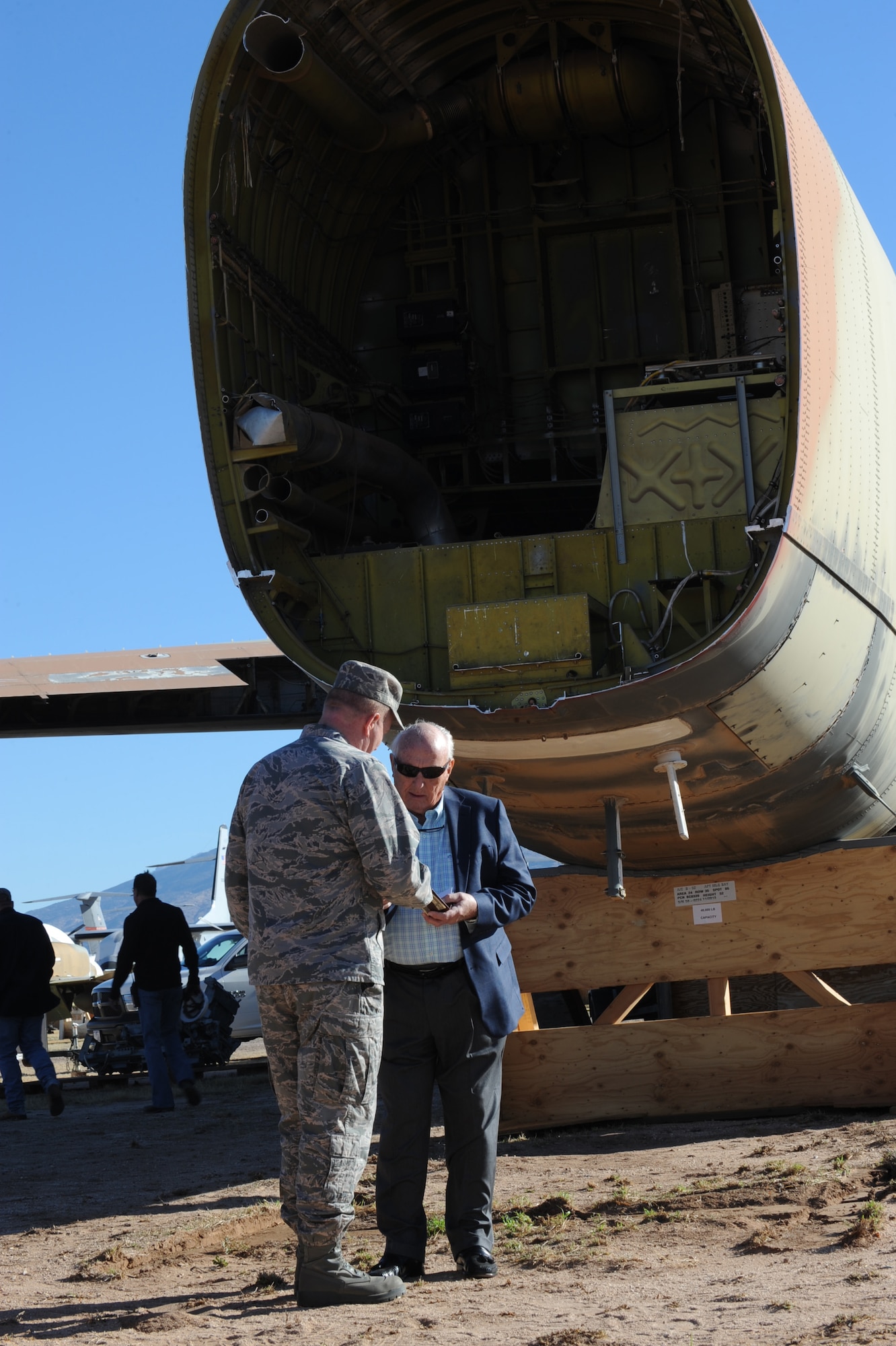 U.S. Air Force Col. Rober Lepper, 309th Aerospace Maintenance and Regeneration Group commander, talks to Retired General Earl O'Loughlin after "The final elimination of the B-52G" ceremony at the Aerospace Maintenance and Regeneration Group, Davis-Monthan Air Force Base, Ariz,. Dec. 19, 2013. In compliance with the New START treaty the aircraft will remain in place for sixty days in order for Russian satellites to confirm its elimination. (U.S Air Force photo by Staff Sgt. Angela Ruiz/released)