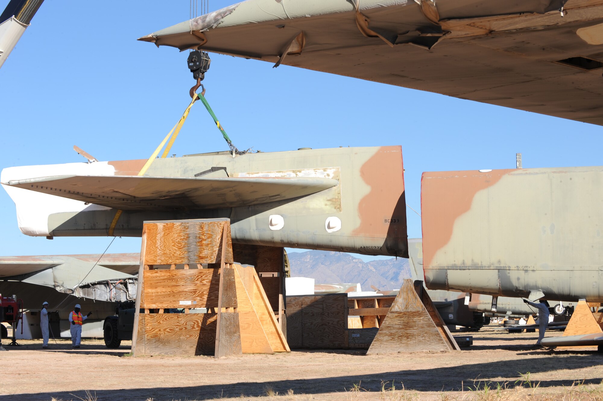 U.S. Air Force personnel from the 578th Storage and Disposal Squadron lift a B-52G's tail section onto a custom-made cradle at the 309th Aerospace Maintenance and Regeneration Group, Davis-Monthan Air Force Base, Ariz., Dec, 19, 2013. The cradle is purposely placed 30 degrees off center and a minimum of six feet apart from the aircraft's fuselage in order for Russia's satellites to verify the elimination. (U.S Air Force photo by Staff Sgt. Angela Ruiz/released)