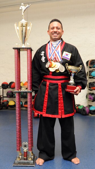 Retired Master Sgt. Amado Garcia, who was previously assigned to the 96th Aircraft Maintenance Squadron, Eglin Air Force Base, Fla., stands with various awards he’s earned during his career as a Kuk Sool Won practitioner at the Aderholt Gym on Hurlburt Field, Fla., Dec. 2, 2013. Garcia has studied and taught Kuk Sool Won for more than 20 years. (U.S. Air Force photo/Senior Airman Kentavist P. Brackin) 