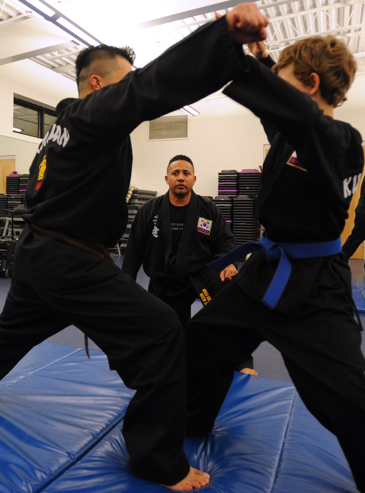 Retired Master Sgt. Amado Garcia, who was previously assigned to the 96th Aircraft Maintenance Squadron, Eglin Air Force Base, Fla., coaches students through stances during a Kuk Sool Won class at the Aderholt Gym on Hurlburt Field, Fla., Nov. 26, 2013. Garcia is a 5th degree black belt and has promoted more than 50 black belts since he began instructing. (U.S. Air Force photo/Senior Airman Kentavist P. Brackin)