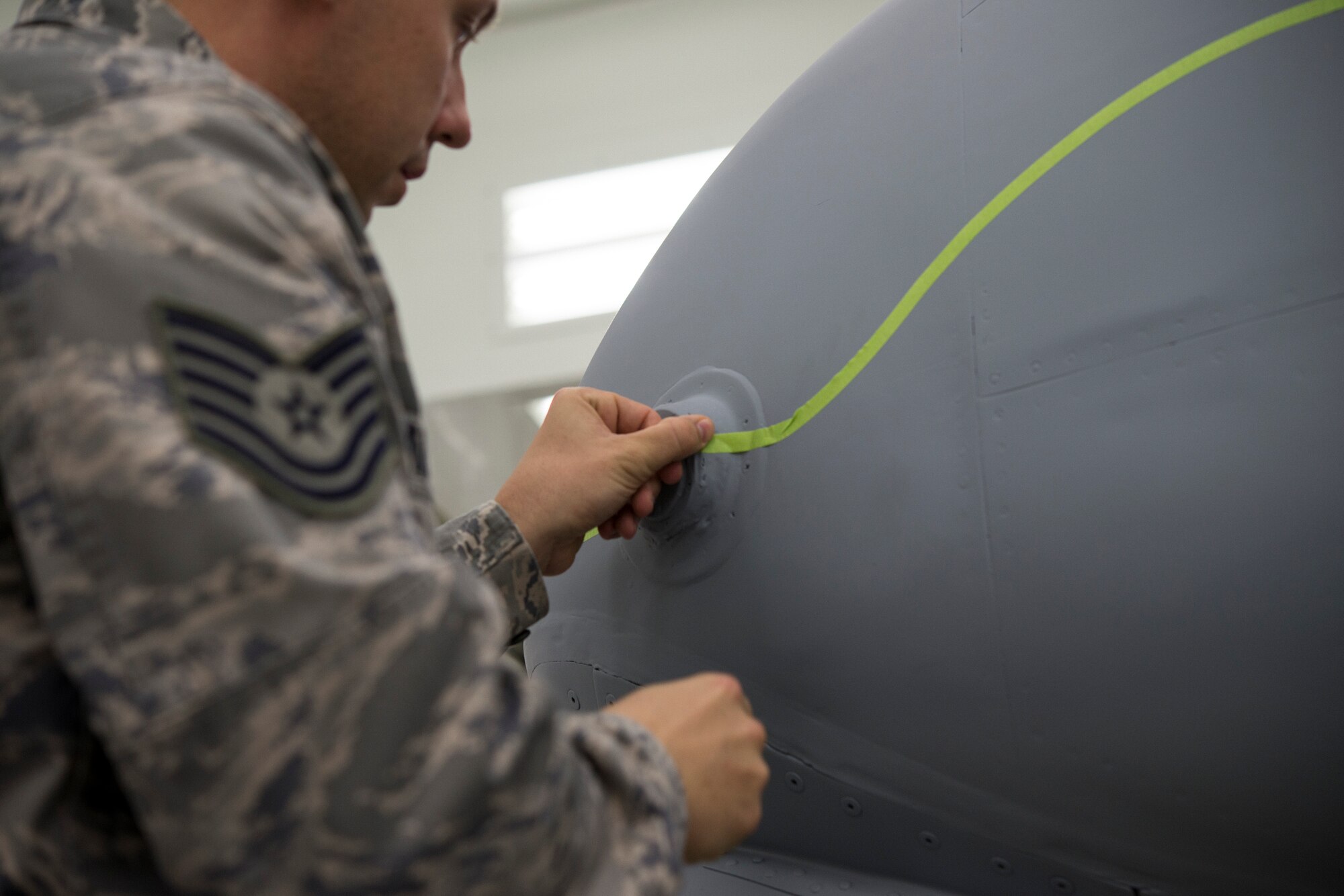 U.S. Air Force Tech. Sgt. Seth Atkinson, 23d Wing corrosion manager, puts stencils on an A-10C Thunderbolt II before it gets painted at the renovated paint facility at Moody Air Force Base, Ga., Dec. 17, 2013. Airmen at the facility repaint aircraft with deteriorating paint to prevent metal corrosion. (U.S. Air Force photo by Airman 1st Class Sandra Marrero/Released)
