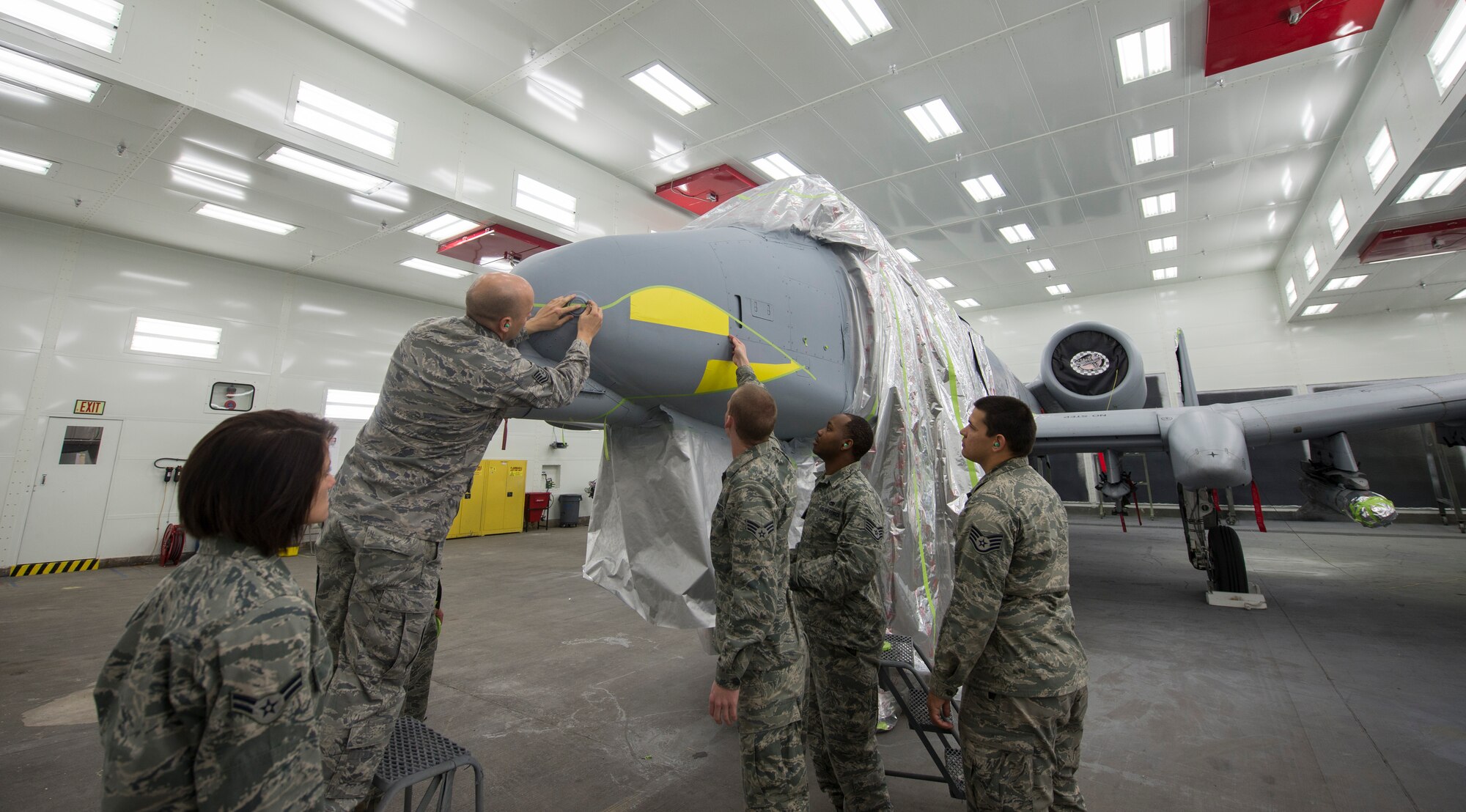 Members of the 23d Equipment Maintenance Squadron fabrication flight stencil teeth on an A-10C Thunderbolt II before it gets painted Dec. 17, 2013, at Moody Air Force Base, Ga. Operations reinitiated at the base paint facility after a yearlong, $4 million dollar renovation project. (U.S. Air Force photo by Airman 1st Class Sandra Marrero/Released)
