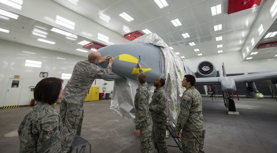 Members of the 23d Equipment Maintenance Squadron fabrication flight stencil teeth on an A-10C Thunderbolt II before it gets painted Dec. 17, 2013, at Moody Air Force Base, Ga. Operations reinitiated at the base paint facility after a yearlong, $4 million dollar renovation project. (U.S. Air Force photo by Airman 1st Class Sandra Marrero/Released)

