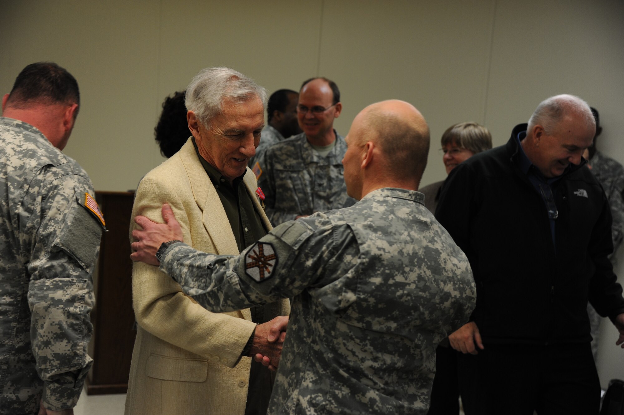 An Army Support Activity-Fort Dix Soldier congratulates John F. Flynn, a World War II-era Army sergeant, after Flynn’s Bronze Star medal presentation Dec. 17, 2013, in the U.S. Army Reserve Mobilization Museum at Joint Base McGuire-Dix-Lakehurst, N.J. ASA-Fort Dix Soldiers joined Flynn’s family to show support for the award presentation. (U.S. Air Force photo by Airman 1st Class Sean M. Crowe/Released)