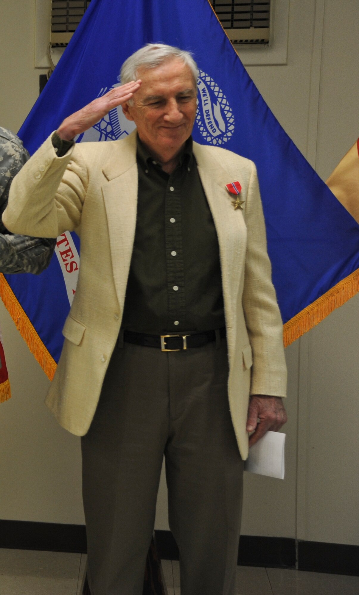 John F. Flynn, World War II-era Army sergeant, salutes after being officially awarded the Bronze Star medal Dec. 17, 2013, in the U.S. Army Reserve Mobilization Museum at Joint Base McGuire-Dix-Lakehurst, N.J. Flynn, a Philadelphia native who currently resides in Egg Harbor, N.J., earned the medal Feb. 1, 1945, while serving with Company D, 1st Battalion, 393rd Infantry Regiment, 99th Infantry Division directly engaging the enemy in ground combat. (U.S. Air Force photo by Airman 1st Class Sean M. Crowe/Released)