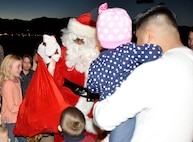 PETERSON AIR FORCE BASE, Colo. Santa Claus greets children and parents on the flightline Dec. 19 here after departing a C-130 aircraft. Active duty members of the 52nd Airlift Squadron hosted a Christmas party and potluck for members of the Air Force Reserve Command’s 302nd Airlift Wing and their families. (U.S. Air Force photo/Master Sgt. Daniel Butterfield)