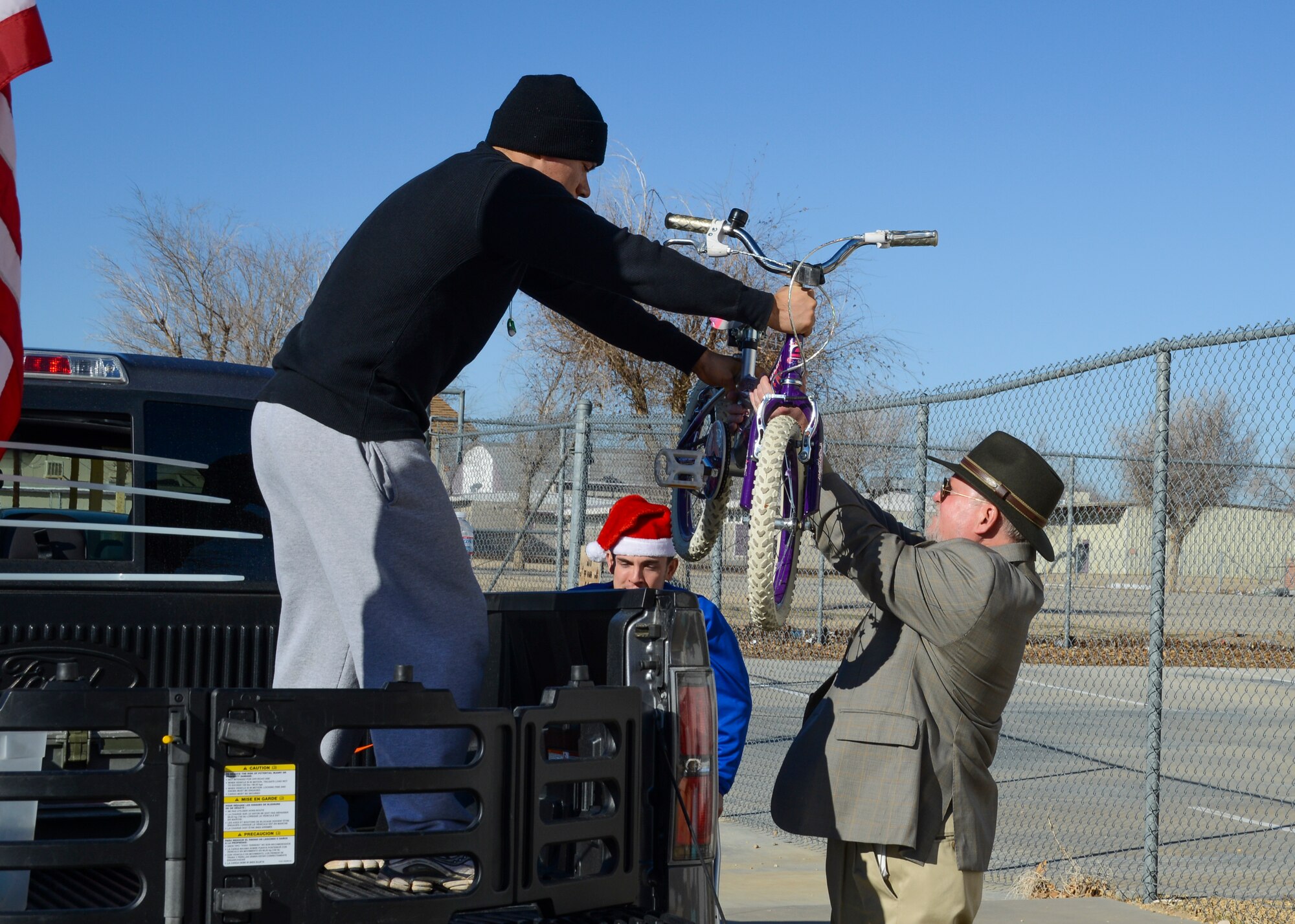 Carl Guilford (right), Program Director of the A. Miriam Jamison Children’s Center, receives a child’s bicycle for the center. (U.S. Air Force photo by Rebecca Amber)