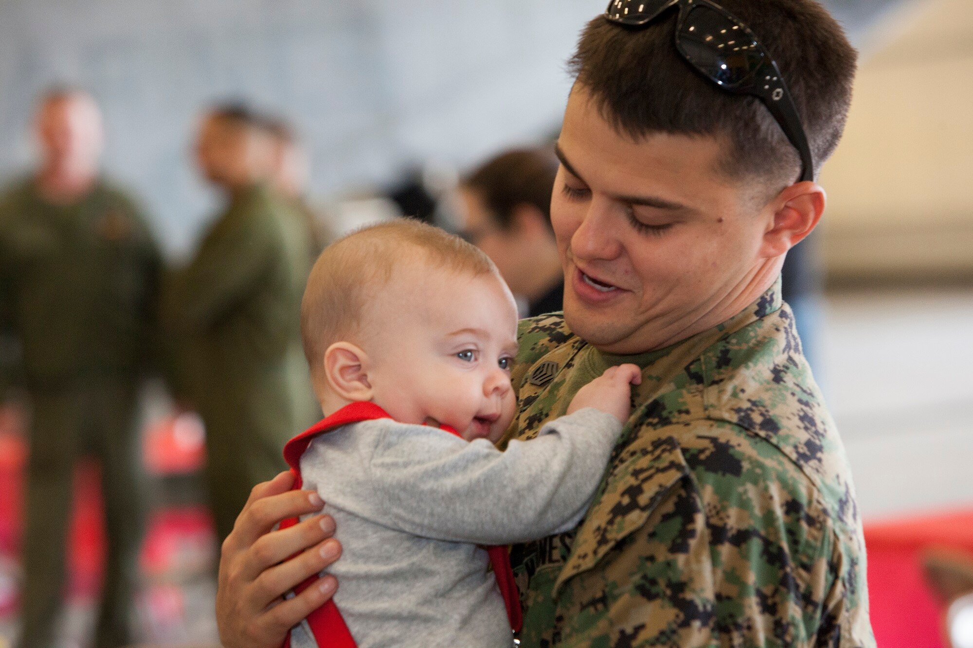 Marine Staff Sgt. Corey Carlson, Marine Heavy Helicopter Squadron (HMH) 772 airframe quality assurance representative, embraces his son, Mason, age five months, during the welcome home ceremony Dec. 5, 2013, on Joint Base McGuire-Dix-Lakehurst, N.J. HMH-772 Detachment 1 returned from a six-month deployment to Marine Corps Air Station Futenma, Japan, as part of the Marine Forces Reserve's participation in the Unit Deployment Program. For Carlson, a native of Roseburg, Ore., this was the second time seeing his son since being deployed. (U.S. Air Force photo by Wayne Russell/Released)