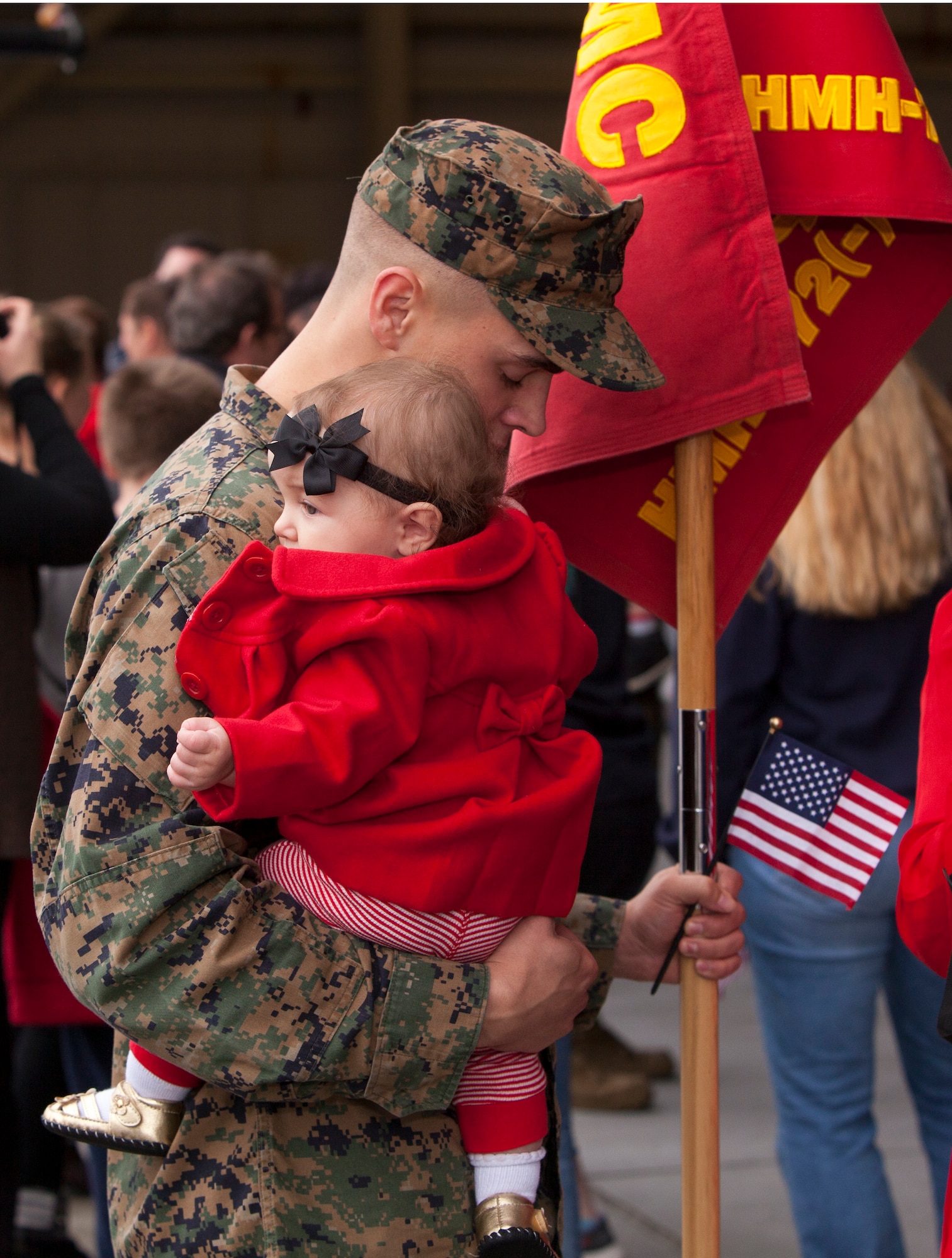 Marine Sgt. Zachary Cochran, Marine Heavy Helicopter Squadron (HMH) 772 ordnance technician, takes a moment while holding his six-month old daughter, Hailee, while still holding his squadron guideon after returning from a six-month deployment with HMH-772 to Marine Corps Air Station Futenma, Japan, as part of the Marine Forces Reserve's participation in the Unit Deployment Program Dec. 5, 2013, on Joint Base McGuire-Dix-Lakehurst, N.J. Cochran hails from Waynesboro, Miss. (U.S. Air Force photo by Wayne Russell/Released)